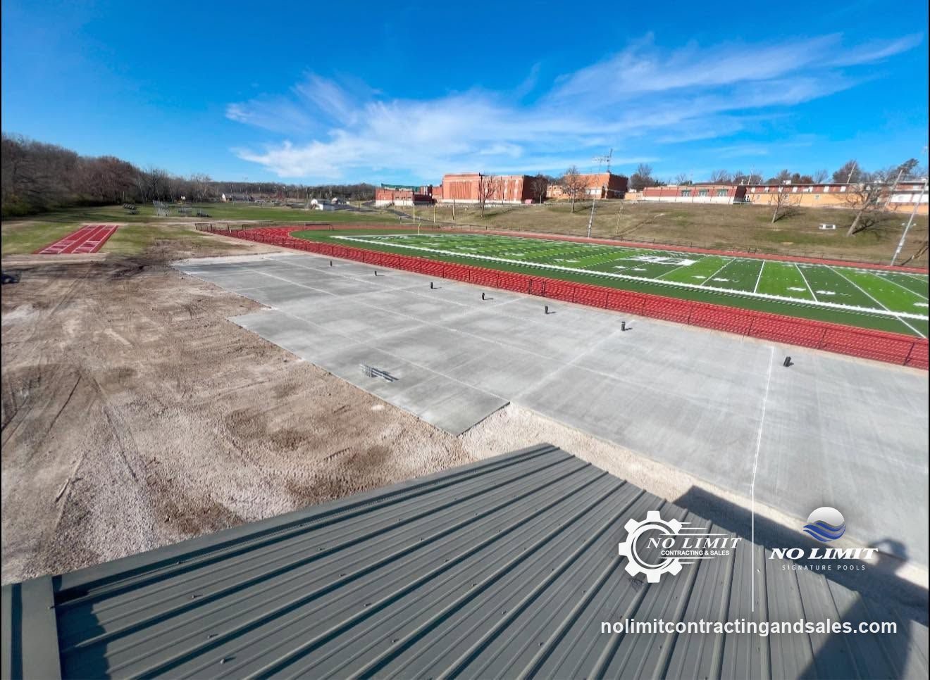 Commercial concrete slab poured beside a school football field and track by No Limit Contracting & Sales