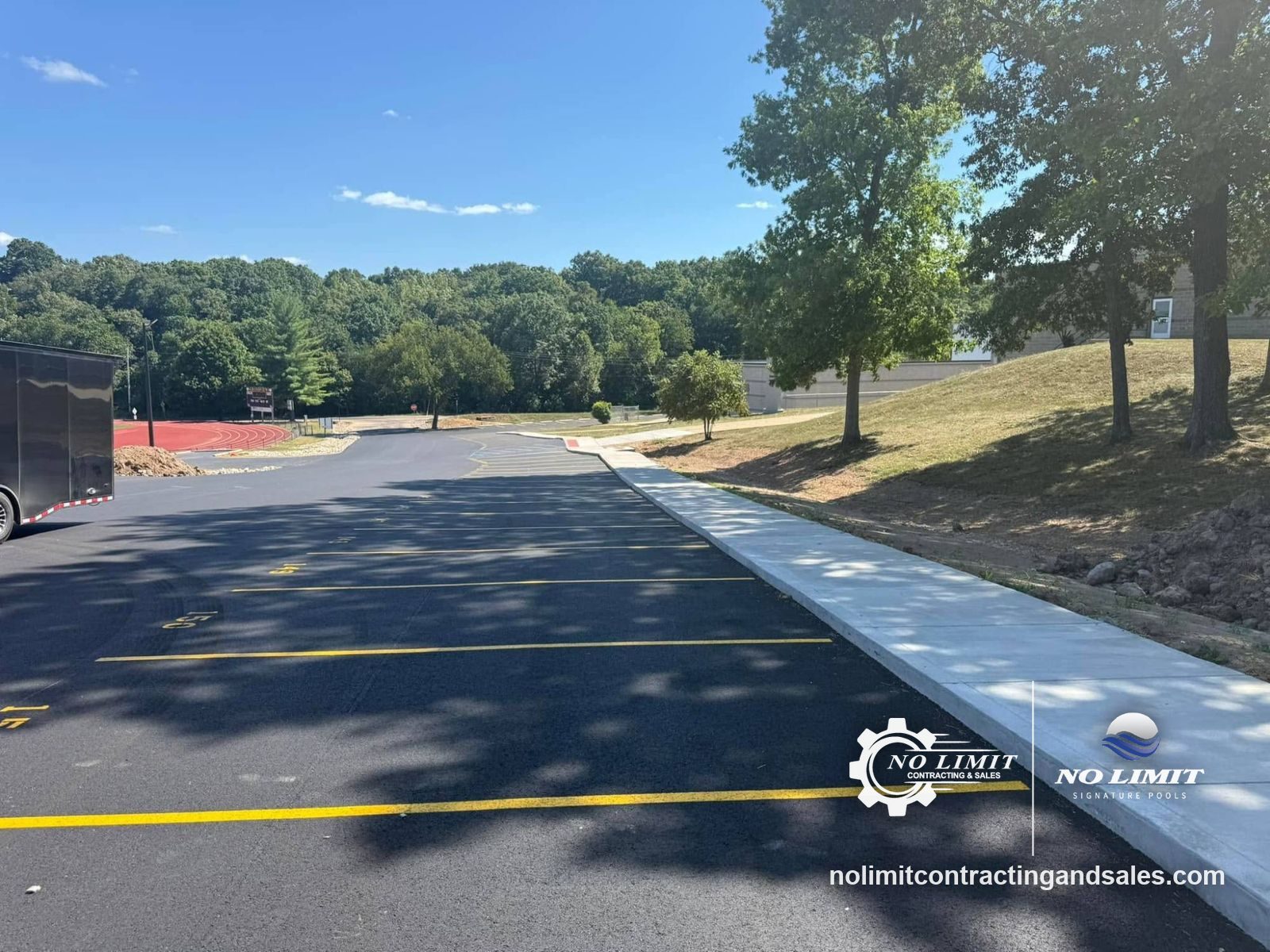 New concrete sidewalk and curb along a school parking lot by No Limit Contracting & Sales