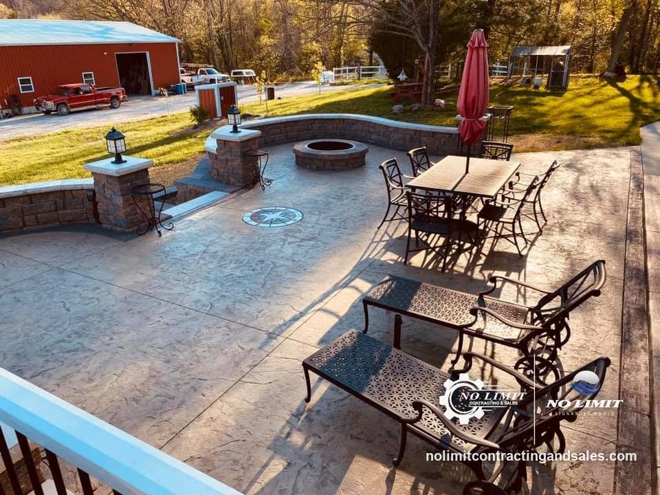Stamped patio with seat walls, lantern pillars, fire pit, compass inlay, furniture by No Limit Contracting & Sales