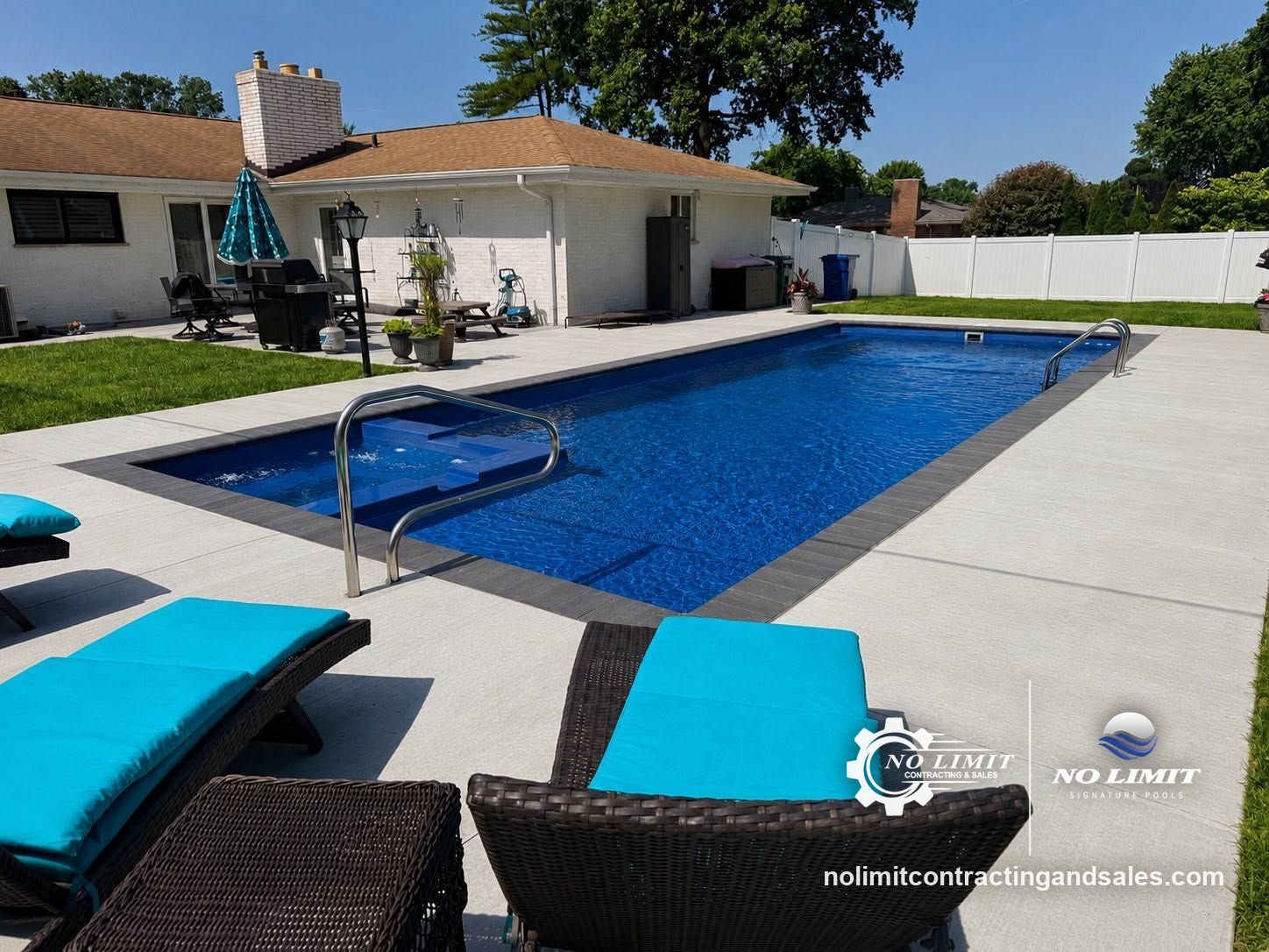 Rectangular fiberglass pool with a deep blue finish and charcoal paver coping by No Limit Signature Pools